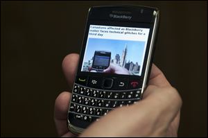 A Blackberry subscriber holds a Research in Motion Blackberry.