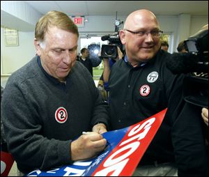 Teamsters president Jim Hoffa autographs a protest sign for local teamster Mark Wilson during a rally at Teamster Local 20 on Wednesday, Oct. 12, 2011. Hoffa was on hand to speak against Issue 2.
