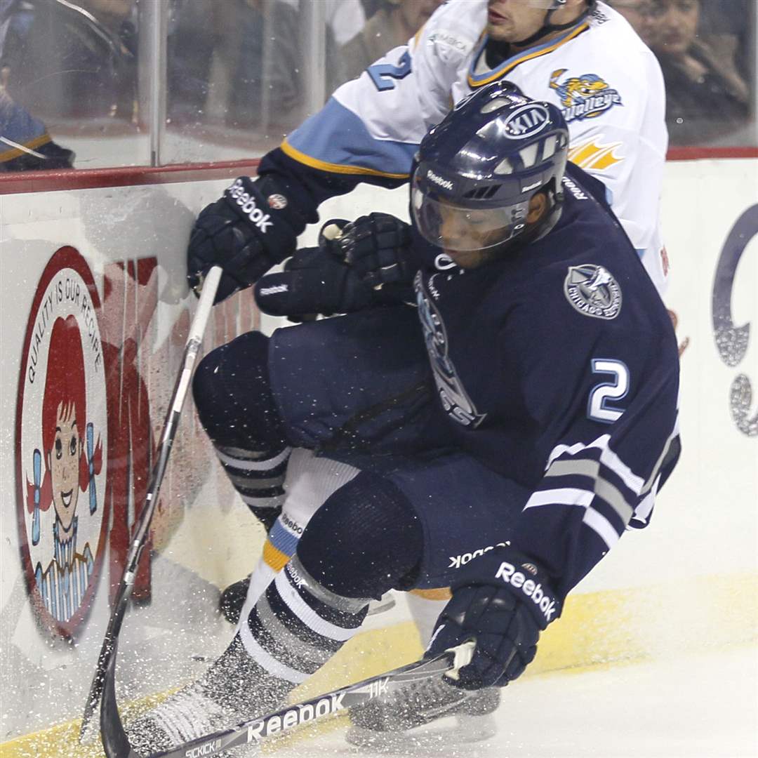 Express-player-Drew-Paris-slams-into-the-boards-with-a-Walleye-in-tow