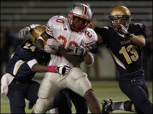 St. John's defenders, including Jamahl Jones, Jake Wheeler (not seen) and Cam Brickman take down Central running back Amir Edwards.
