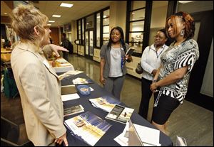 Amy Wexler, career development specialist with Herzing University, talks with Herzing  graduates from left, Veronica Sanders, Olean Cherry, and Gwendolyn Mitchell, all of Toledo, at the Hispanic Chamber of Commerce Expo and Job Fair at the University of Toledo.