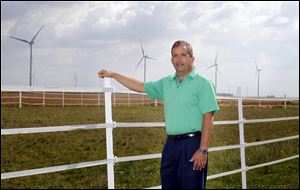 County Commissioner Tony Zartman, who lives at 4376 Road 33, stands in his Benton Township backyard where several wind turbines spin in the distance.