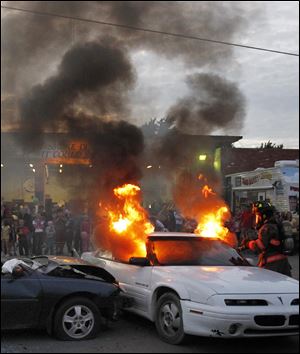 Rossford firefighter Ryan Hennessey puts out a car fire during the open house.