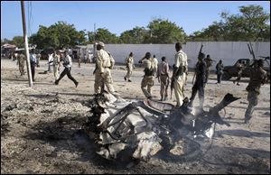 Somali government forces attend the scene of a car bomb in Mogadishu, Somalia.