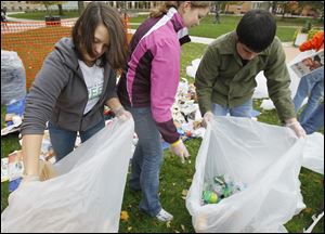 Bowling Green State University students Kaitlyn Bailey, Amber Mathias and Marc Garcia sort recyclables on Tuesday on the school's campus. Campus groups Net Impact sorted through two-days' worth of trash from a campus building to demonstrate the amount of trash that could be recycled.