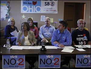 Betty Evans, who has taught in Toledo Public Schools for 21 years, speaks against Issue 2 with Dan Greenberg, an English teacher in Sylvania’s Southview High School, front middle, and Perry Lefevre, president of the Sylvania Education Association union, front right.