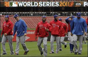 Members of the Texas Rangers take a walk during their workout yesterday at Busch Stadium in St. Louis  where the World Series opens tonight. But minus big-market teams, and at a time when TV ratings for baseball games are dwindling,  national interest may be down.