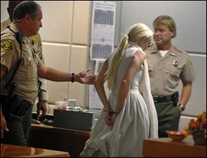 Lindsay Lohan is taken into custody by Los Angeles Country sheriffs after a judge finds her in violation of probation.
