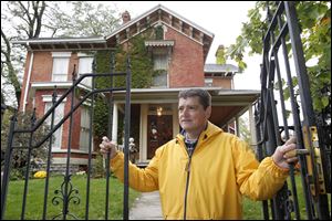 Richard Martinez chairman of the Vistula Historic District Commission, with vacant homes on Elm Street, and his home on North Superior Street, in Toledo, Thursday.