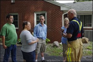 Steve Chamberlin, left, Jessica Swaisgood, Geoff Dennis, and Amy Knauss talk with Bowling Green fire department Lt. Mike Leestma during filming this summer. Ms. Swaisgood is a home supervisor for Wood Lane. Ms. Knauss is a staff member.