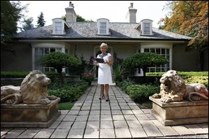 Real estate agent Ronni Keating waits outside a home in Bloomfield Hills, Mich. In the luxury sector, the recession is a memory and prices are rising. But everywhere else, the housing market is still suffering.