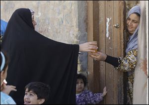 Umm Mohammed distributes sweets and juice as she celebrates the announcement that after nearly nine years of war, U.S. troops are to withdraw. Yet some Iraqis fear violence will worsen and Iran's influence will increase.