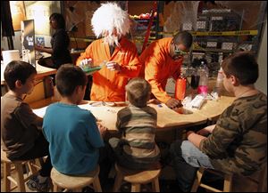 Mad scientist Joseph Brinkman, left, and Jason Pope help young visitors to Toledo's Imagination Station make slime during the first of two Spooky Science weekends at the downtown science center. 