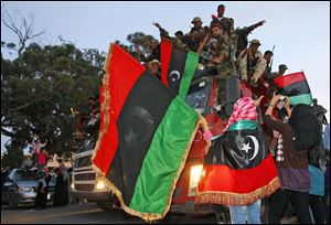 Libyan revolutionary fighters returning from Sirte are welcomed at Al Guwarsha gate in Benghazi, Libya, Saturday.