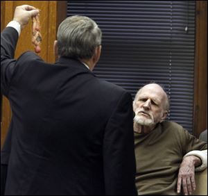 Assistant Lucas County prosecutor John Weglian, left, holds evidence, a Spiderman doll, while cross examining Robert Bowman.