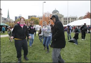Volunteers Bridget Willeman, of Toledo, left, and Michael Williams, also of Toledo, dancing to the Electric Slide with other people at Tent City.