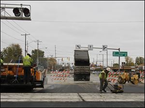 Pavement is installed as part of the rail reconstruction on Dorr Street. The work should allow, by late this year or early next year, bigger trains to pull in or out without delaying other trains on Norfolk Southern’s main line through Toledo.