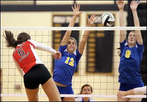 St. Ursula's Madison Strall (12) and Lauran Graves (8) defend against Central Catholic's Jennifer Kowalski during the Arrows' three-set victory in the Division I district final.