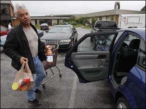 David Estrada returns to his car after receiving groceries from the Food for Thought pantry in Oregon. He started going to the pantry more than a year ago.