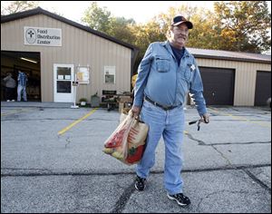 Michael Moore of Perrysburg Township leaves with food from Perrysburg Christians United’s food pantry. The visit to the charity was his first.