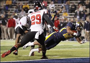 University of Toledo WR Eric Page (12) scores a touchdown against Northern Illinois LB Jordan Delegal (29) during the first quarter Tuesday, at the Glass Bowl in Toledo.