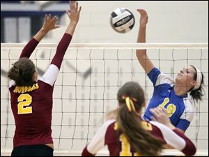 St. Ursula's Maddie Burnham (19) spikes the ball.