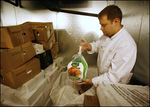 Jim Bailey, facility manager at the Cherry Street Mission Madison Food Services Facility, holds one of the few turkeys the mission has received.  The organization is trying to fill 550 food boxes for the needy. 