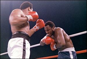 In this 1975, file photo, heavyweight boxer Joe Frazier grimaces after Muhammad Ali, left, landed a blow to Frazier's head during their boxing bout in Manila, the Philippines. Ali won the fight after Frazier's manager stopped the fight in the 14th round. Frazier, the former heavyweight champion who handed Ali his first defeat yet had to live forever in his shadow, has died after a brief final fight with liver cancer. He was 67. 
