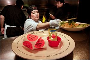 Stickers to mark food as gluten-free rest on a plate next to a cup for organic sauce at a P.F. Chang’s. The chain offers customized vegetarian menus as well as kosher items.
