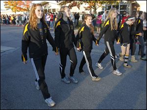 The state meet-bound Northview girls' cross country team, including, from left, Mo Dean, Rachel Audt and Laura Judge, enjoy a send-off from the entire student body outside of the Sylvania high school.