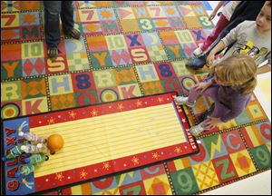 Douglas Road Elementary School kindergartener Winzor Marston, 5, knocks down pins in a "pumpkin bowling" game during the school's harvest festival.