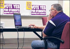Paul Brotzki, treasurer of Maumee City Schools, monitors voting results.