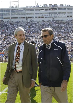 Penn State president Graham Spanier, left, and head football coach Joe Paterno chat before an NCAA college football game against Iowa in State College, Pa.