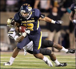 University of Toledo WR Eric Page runs the ball  against  Western Michigan's Donald Celiscar (34) during the second quarter Tuesday.