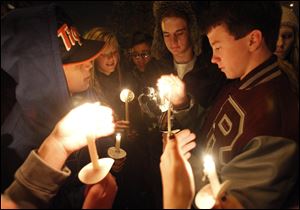 Students from left: A.J. Santellana, Lyndsey Skala, Noah Asmus, and C.J. Ball, light candles during a vigil for Rossford High School junior Kerry Keller who is battling cancer.