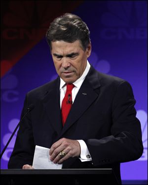 Republican presidential candidate Texas Gov. Rick Perry looks at his notes Wednesday during a Republican Presidential Debate at Oakland University in Auburn Hills, Mich.