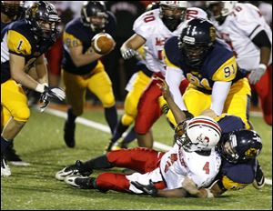 Canton McKinley's Tyler Foster is sacked by Whitmer's Nathan Holley and fumbles as Michael Moore moves in. Whitmer recovered the ball in the third quarter. 