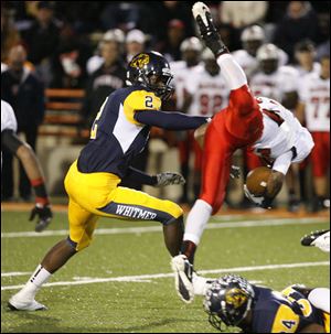 Terrance Burt is upended by Whitmer's Jody Webb (34) on ground as Nigel Hayes (2) gives him a push in the first half.  