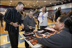 Ed Plocek, left, and brother Tony stop by wrestler Rhino's table at Springfield High School. At right is Lindsay Christie of the Crissey Elementary Parent Club.