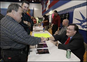 Tony Plocek shakes hands with wrestler The Paul Bearer at the benefit wrestling show at Springfield High School. Tony's brother Ed is second from left.