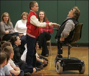 Hunter Suto, 10, shakes the hand of Ronnie Bachman during Mr. Bachman's speech at St. Charles Borromeo Catholic School in Newport, Mich.  Mr. Bachman is a radio and television broadcaster who travels the state, delivering an anti-bullying message to schools.