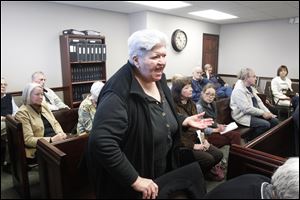 Loretta Miler, from Tiffin, speaks to the county commissioners against the demolition bid for the Seneca County Courthouse during their meeting.