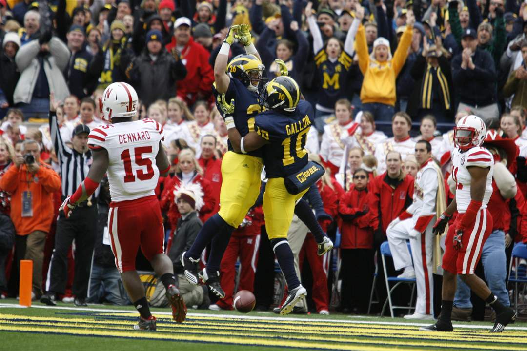 Michigan-players-Drew-Dileo-26-and-Jeremy-Gallon-10-leaps-in-a-TD-celebration