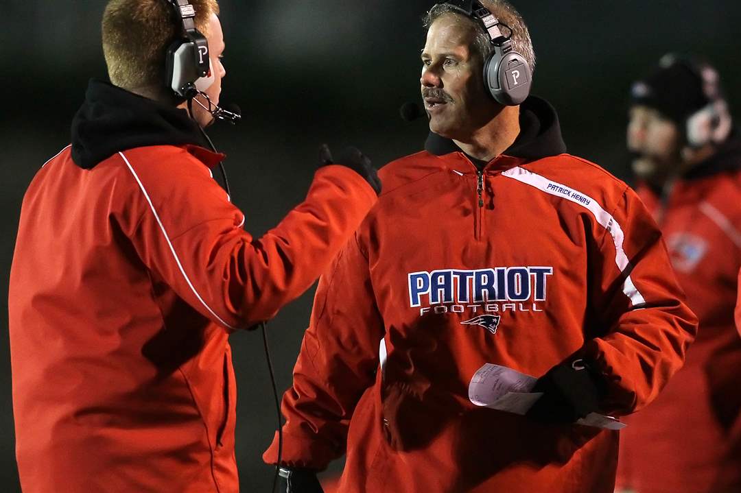 Patrick-Henry-head-coach-Bill-Inselmann-confers-with-his-assistants