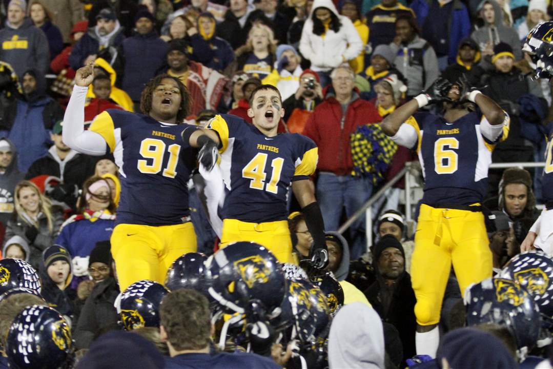 Whitmer-players-Marquise-Moore-91-Alonza-Lucas-6-and-Bryce-Larkin-41-join-fans-in-celebration