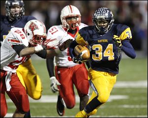 Whitmer's Jody Webb, 34, runs for a first down as Wadsworth's Charles Edwards, 28, tries to stop him during a Division I state playoff football game in Sandusky, Saturday.