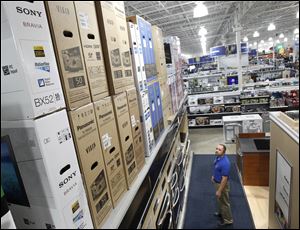 John Lemire, manager of the Best Buy store on Monroe Street in Toledo, checks over televisions stored above a display of ranges as extra stock for the Black Friday sale.  