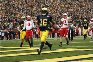 University of Michigan quarterback Denard Robinson (16) out races University of Nebraska players Daimion Stafford (3) and Lance Thorell (23) for a second-quarter touchdown Saturday at the Big House.
