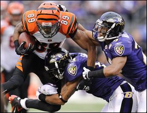 Cincinnati Bengals wide receiver Jerome Simpson (89) is tackled by Baltimore Ravens defenders Jimmy Smith, center, and Cary Williams in the second half in Baltimore, Sunday. Baltimore won 31-24. 