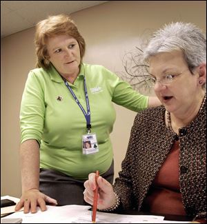 Glenda Plunkett, left, confers with her boss Marilyn Sears, CEO of Shelby Memorial Hospital, in Shelbyville, Ill. Plunkett lost her 11-year American Red Cross job during the recent major overhaul by the Red Cross that cut more than 1,500 jobs and merged many chapters.